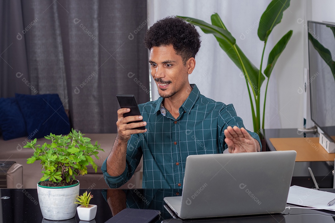 Jovem nômade em uma reunião de teletrabalho em uma mesa com laptop