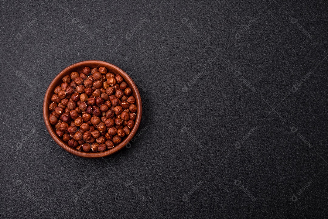 Deliciosa avelã inteira, crua, sem casca, sobre fundo escuro de concreto. Ingrediente calórico