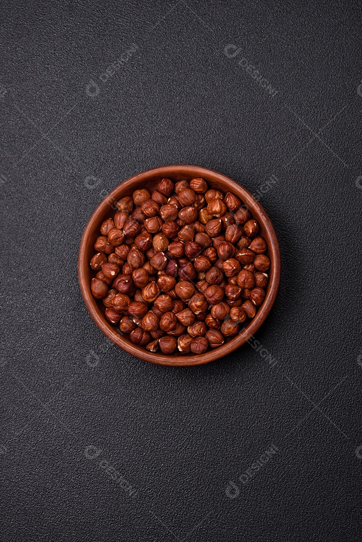 Deliciosa avelã inteira, crua, sem casca, sobre fundo escuro de concreto. Ingrediente calórico