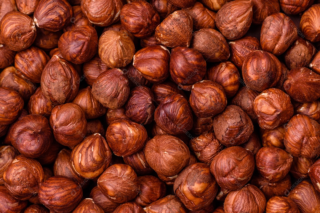 Deliciosa avelã inteira, crua, sem casca, sobre fundo escuro de concreto. Ingrediente calórico