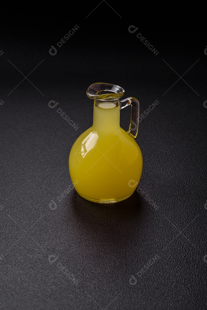 Bebida alcoólica limoncello amarelo em um copo pequeno sobre um fundo escuro de concreto