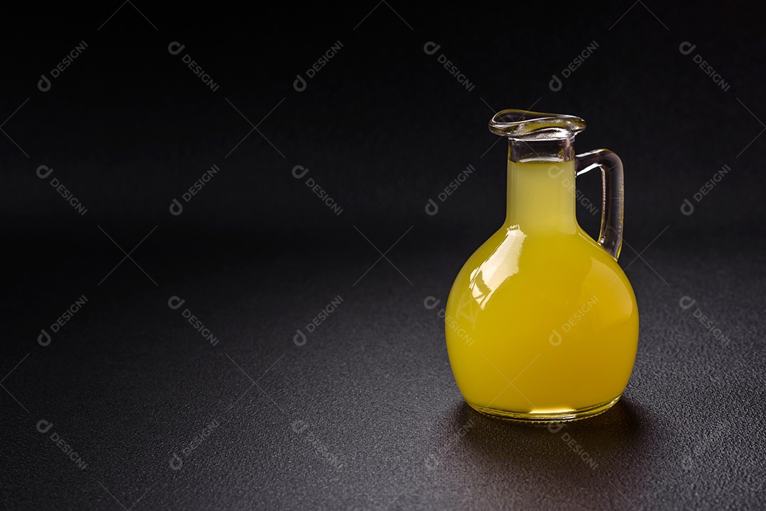 Bebida alcoólica limoncello amarelo em um copo pequeno sobre um fundo escuro de concreto