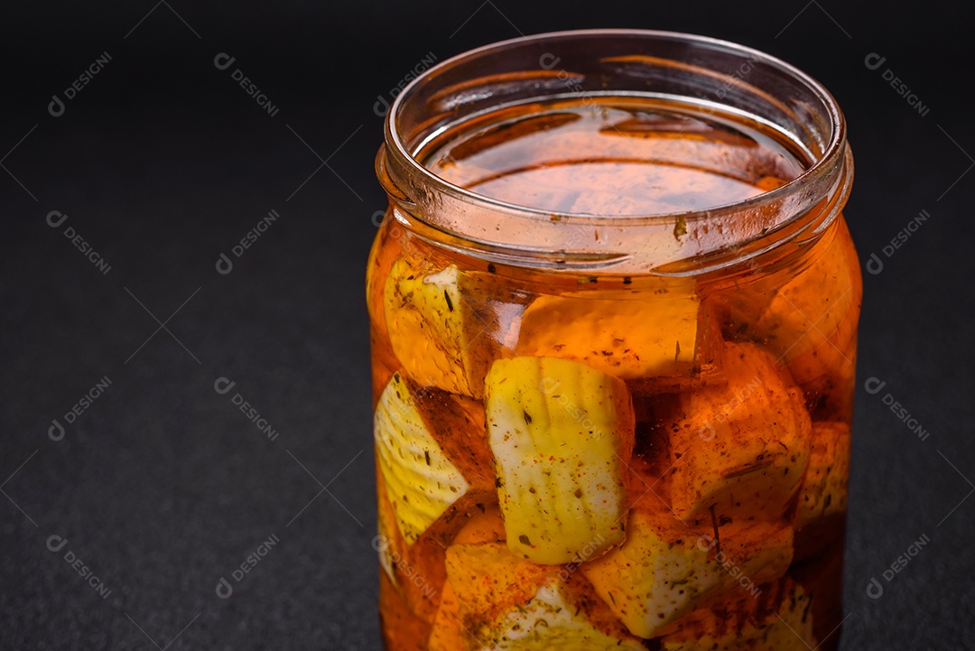 Delicioso queijo feta branco macio com sal, especiarias e ervas sobre um fundo escuro de concreto. Ingredientes para pratos mediterrâneos