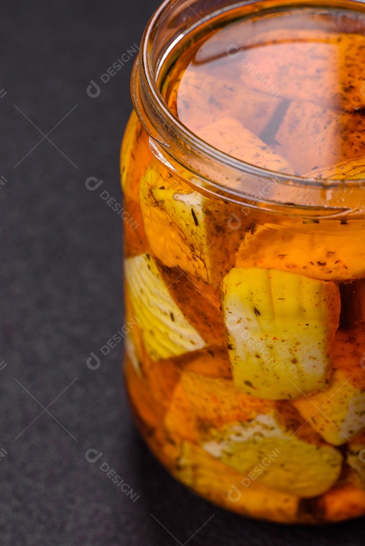 Delicioso queijo feta branco macio com sal, especiarias e ervas sobre um fundo escuro de concreto. Ingredientes para pratos mediterrâneos