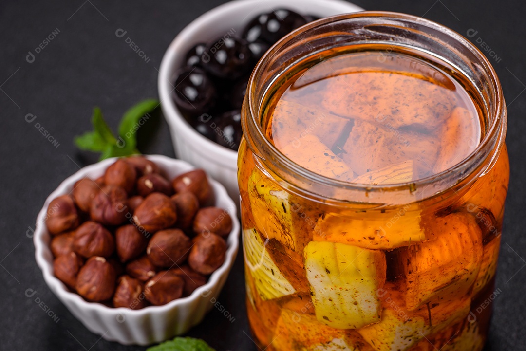 Delicioso queijo feta branco macio com sal, especiarias e ervas sobre um fundo escuro de concreto. Ingredientes para pratos mediterrâneos