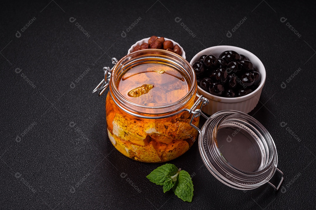 Delicioso queijo feta branco macio com sal, especiarias e ervas sobre um fundo escuro de concreto. Ingredientes para pratos mediterrâneos