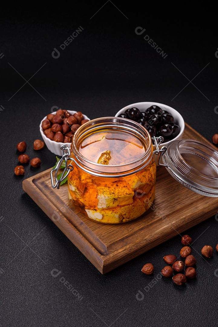 Delicioso queijo feta branco macio com sal, especiarias e ervas sobre um fundo escuro de concreto. Ingredientes para pratos mediterrâneos