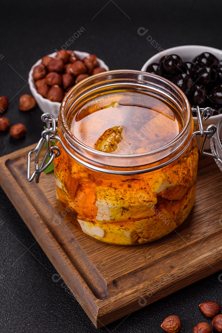 Delicioso queijo feta branco macio com sal, especiarias e ervas sobre um fundo escuro de concreto. Ingredientes para pratos mediterrâneos