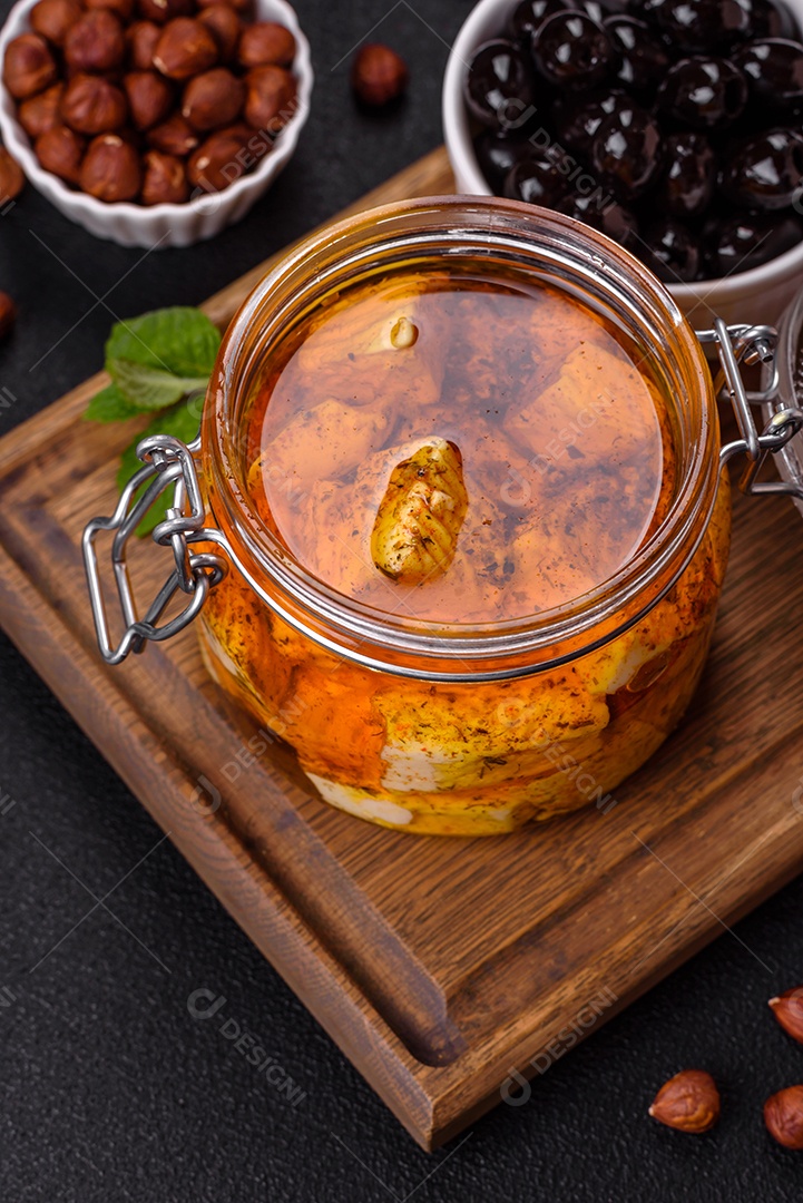 Delicioso queijo feta branco macio com sal, especiarias e ervas sobre um fundo escuro de concreto. Ingredientes para pratos mediterrâneos