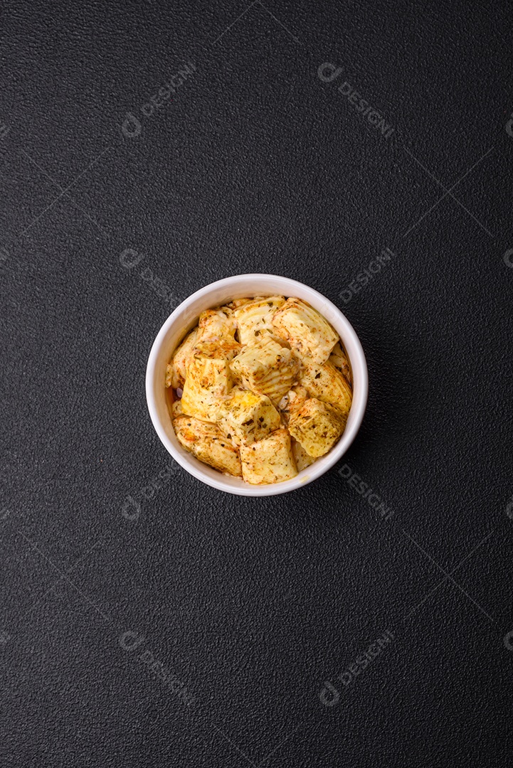 Delicioso queijo feta branco macio com sal, especiarias e ervas sobre um fundo escuro de concreto. Ingredientes para pratos mediterrâneos