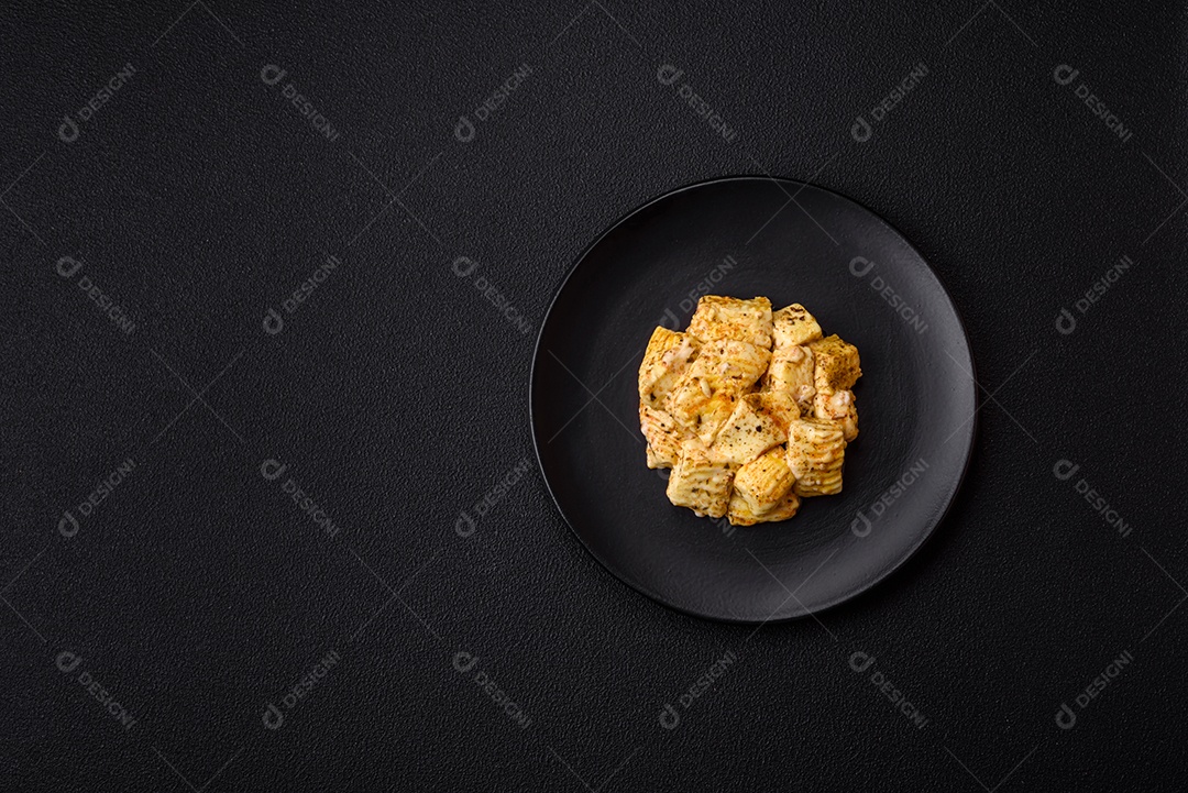Delicioso queijo feta branco macio com sal, especiarias e ervas sobre um fundo escuro de concreto. Ingredientes para pratos mediterrâneos