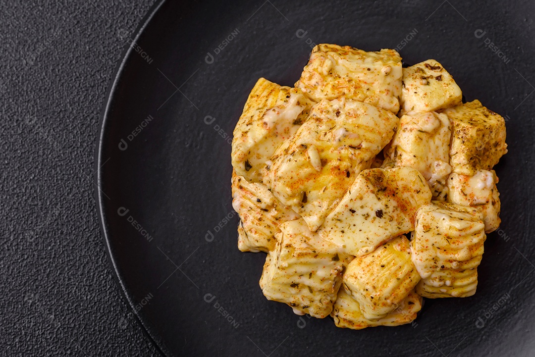 Delicioso queijo feta branco macio com sal, especiarias e ervas sobre um fundo escuro de concreto. Ingredientes para pratos mediterrâneos