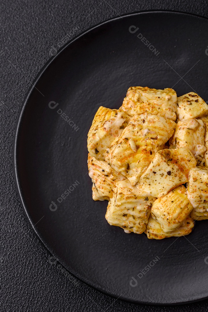 Delicioso queijo feta branco macio com sal, especiarias e ervas sobre um fundo escuro de concreto. Ingredientes para pratos mediterrâneos