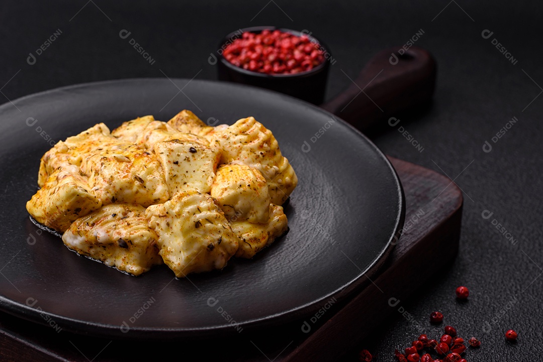 Delicioso queijo feta branco macio com sal, especiarias e ervas sobre um fundo escuro de concreto. Ingredientes para pratos mediterrâneos