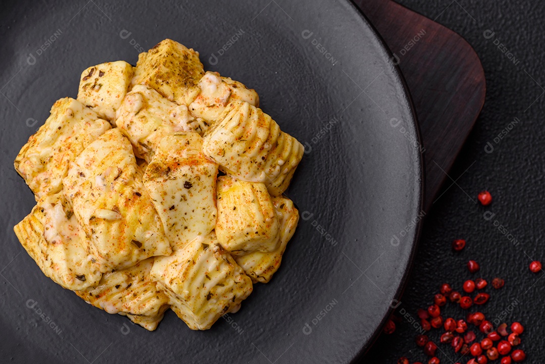 Delicioso queijo feta branco macio com sal, especiarias e ervas sobre um fundo escuro de concreto. Ingredientes para pratos mediterrâneos