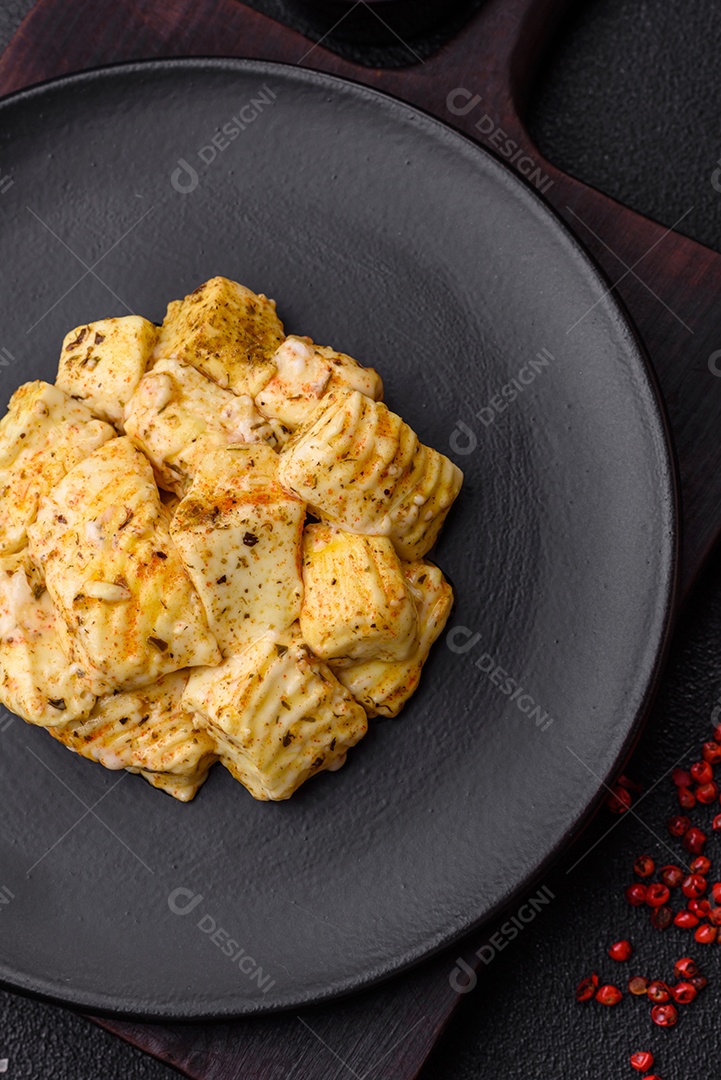 Delicioso queijo feta branco macio com sal, especiarias e ervas sobre um fundo escuro de concreto. Ingredientes para pratos mediterrâneos
