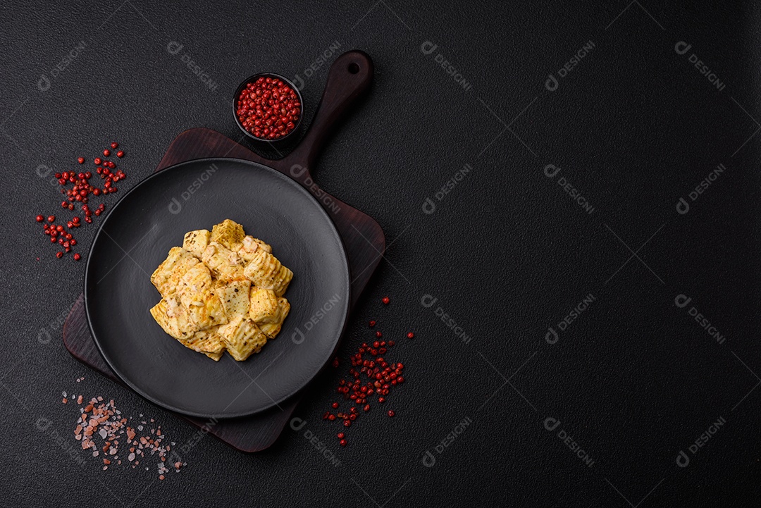 Delicioso queijo feta branco macio com sal, especiarias e ervas sobre um fundo escuro de concreto. Ingredientes para pratos mediterrâneos