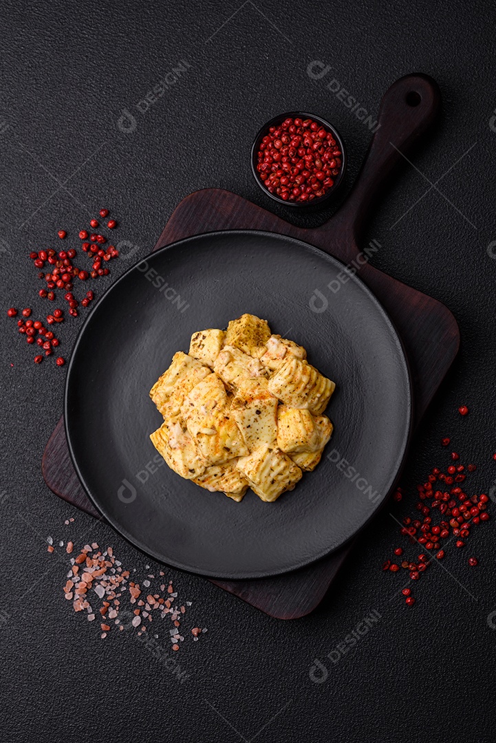 Delicioso queijo feta branco macio com sal, especiarias e ervas sobre um fundo escuro de concreto. Ingredientes para pratos mediterrâneos