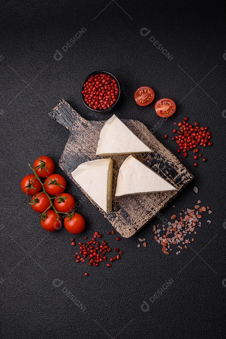 Delicioso queijo jovem branco fresco de leite de vaca ou ovelha sobre um fundo escuro de concreto