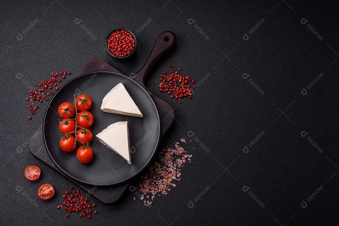 Delicioso queijo jovem branco fresco de leite de vaca ou ovelha sobre um fundo escuro de concreto