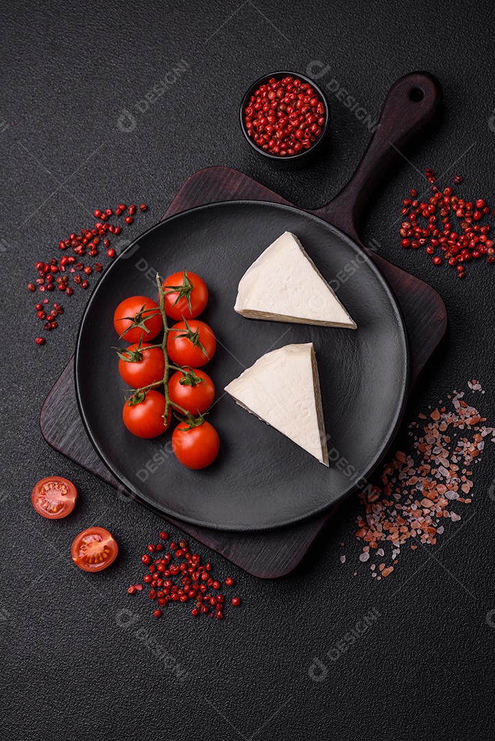Delicioso queijo jovem branco fresco de leite de vaca ou ovelha sobre um fundo escuro de concreto