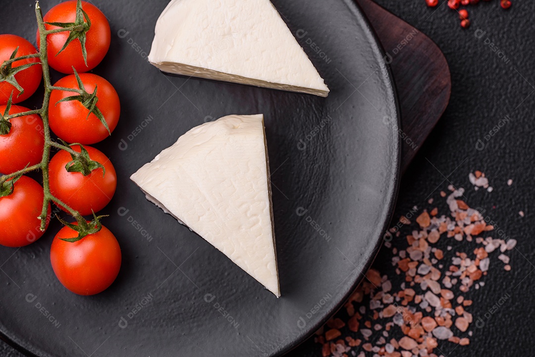 Delicioso queijo jovem branco fresco de leite de vaca ou ovelha sobre um fundo escuro de concreto
