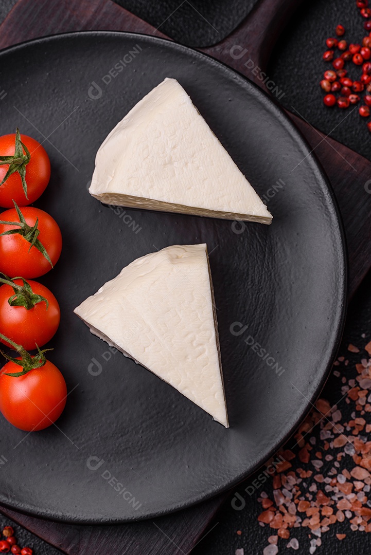 Delicioso queijo jovem branco fresco de leite de vaca ou ovelha sobre um fundo escuro de concreto