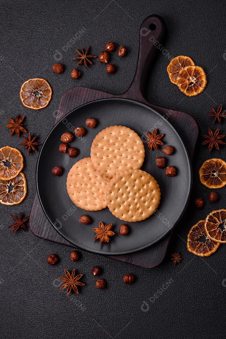 Biscoitos redondos pontilhados com creme em um fundo escuro de concreto. Doces no café da manhã