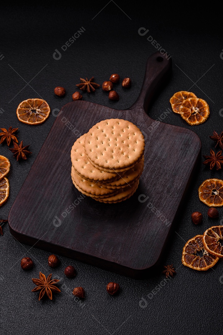 Biscoitos redondos pontilhados com creme em um fundo escuro de concreto. Doces no café da manhã