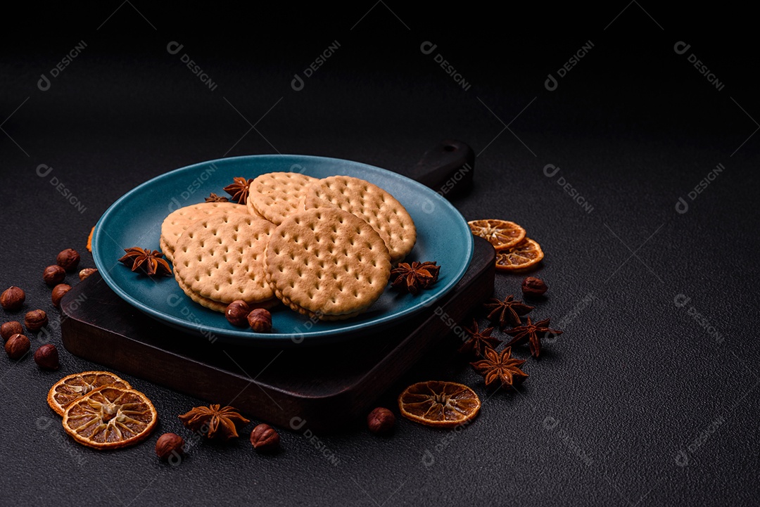 Biscoitos redondos pontilhados com creme em um fundo escuro de concreto. Doces no café da manhã