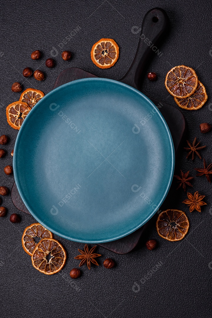 Placa redonda de cerâmica vazia em fundo de concreto texturizado escuro. Talheres, preparação para o jantar