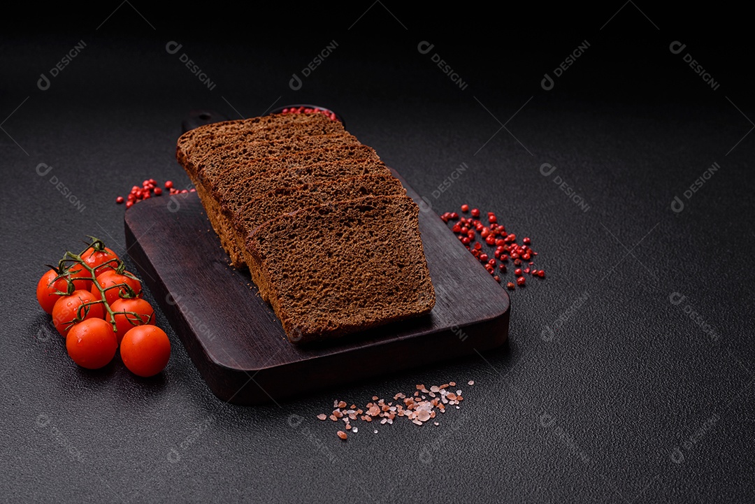 Delicioso pão integral com sementes e grãos cortados em fatias sobre um fundo de concreto texturizado