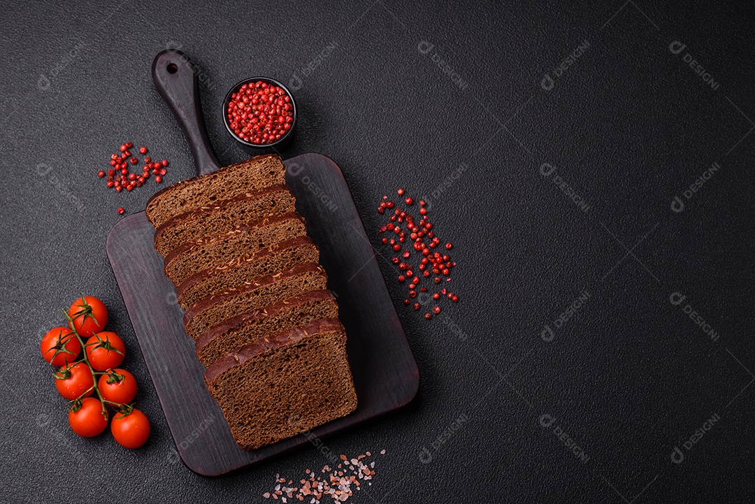 Delicioso pão integral com sementes e grãos cortados em fatias sobre um fundo de concreto texturizado