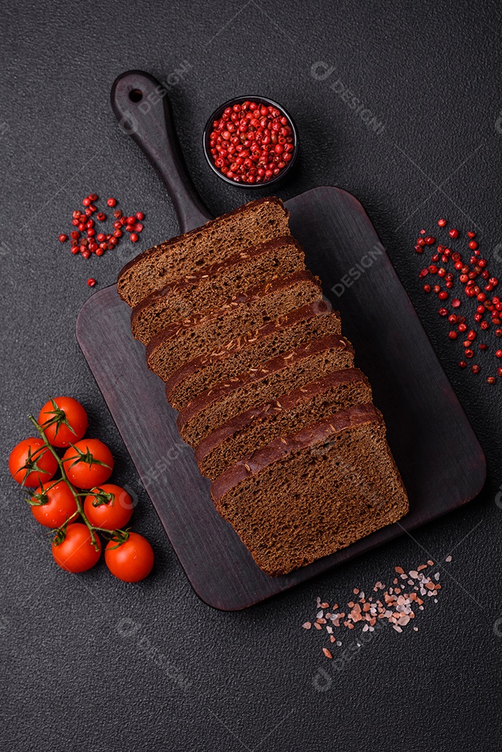 Delicioso pão integral com sementes e grãos cortados em fatias sobre um fundo de concreto texturizado