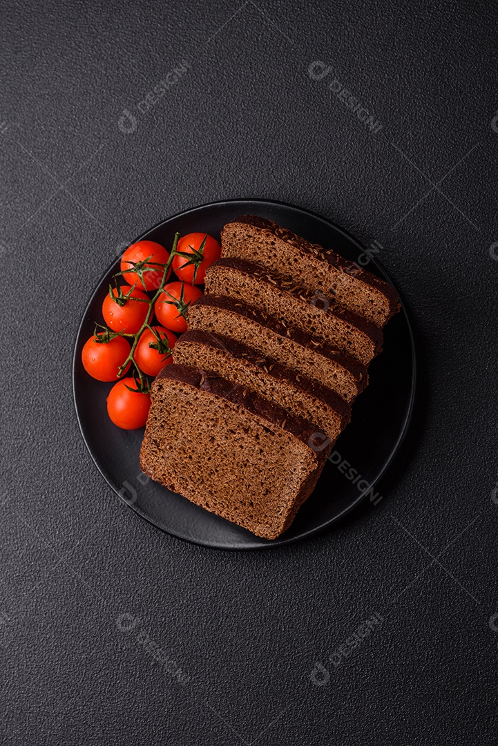 Delicioso pão integral com sementes e grãos cortados em fatias sobre um fundo de concreto texturizado