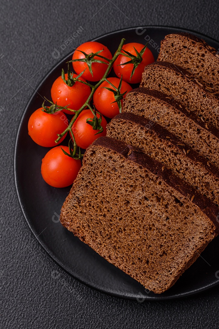 Delicioso pão integral com sementes e grãos cortados em fatias sobre um fundo de concreto texturizado