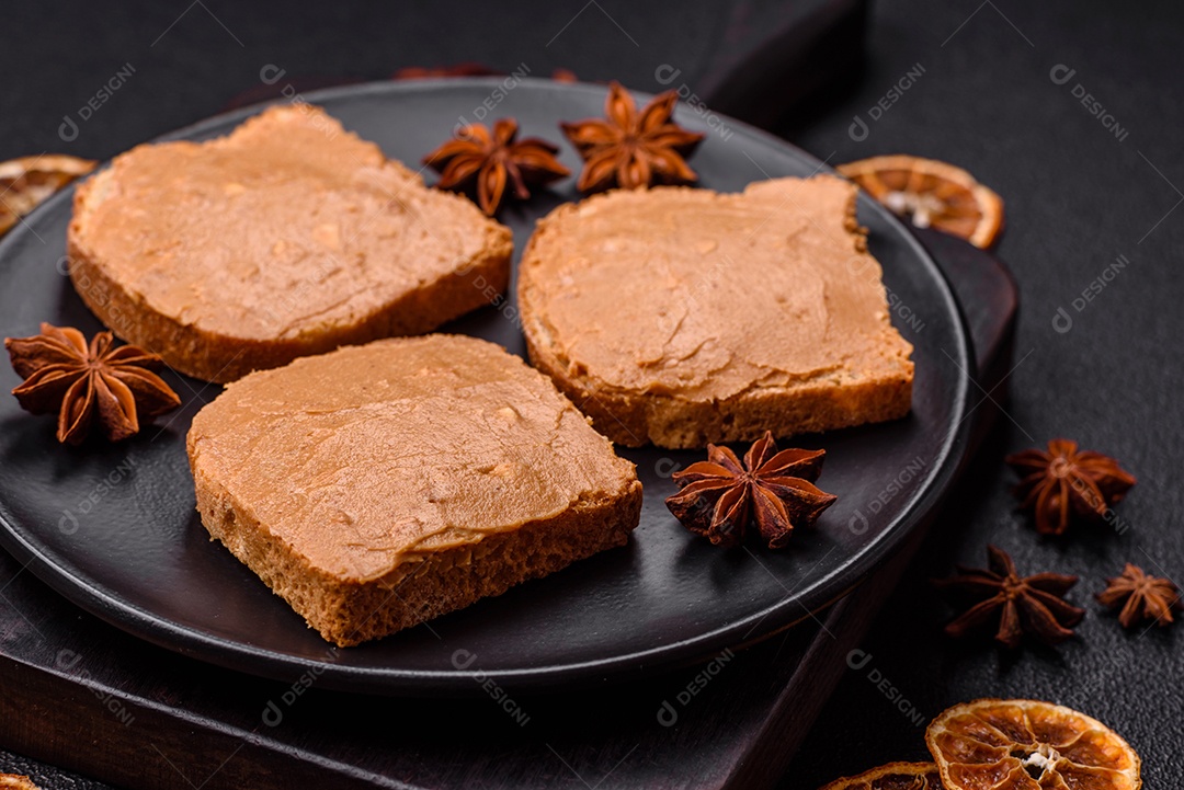 Delicioso sanduíche saudável com pão torrado e manteiga de amendoim em um fundo de concreto texturizado