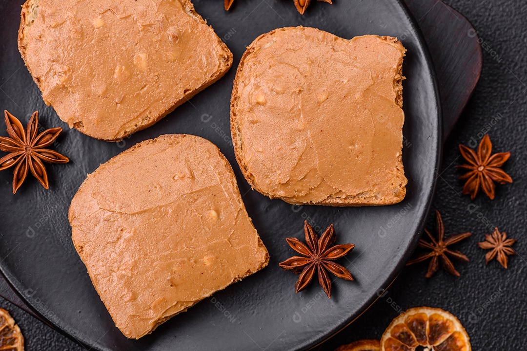 Delicioso sanduíche saudável com pão torrado e manteiga de amendoim em um fundo de concreto texturizado