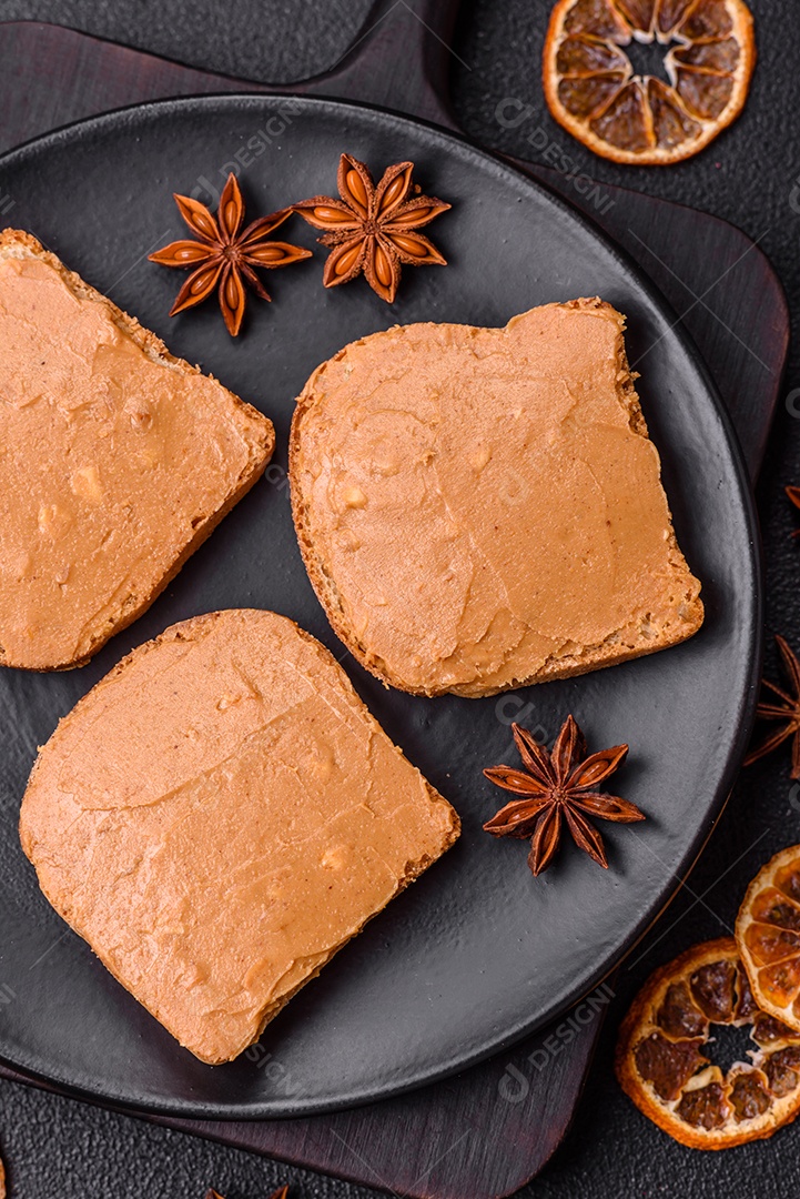 Delicioso sanduíche saudável com pão torrado e manteiga de amendoim em um fundo de concreto texturizado
