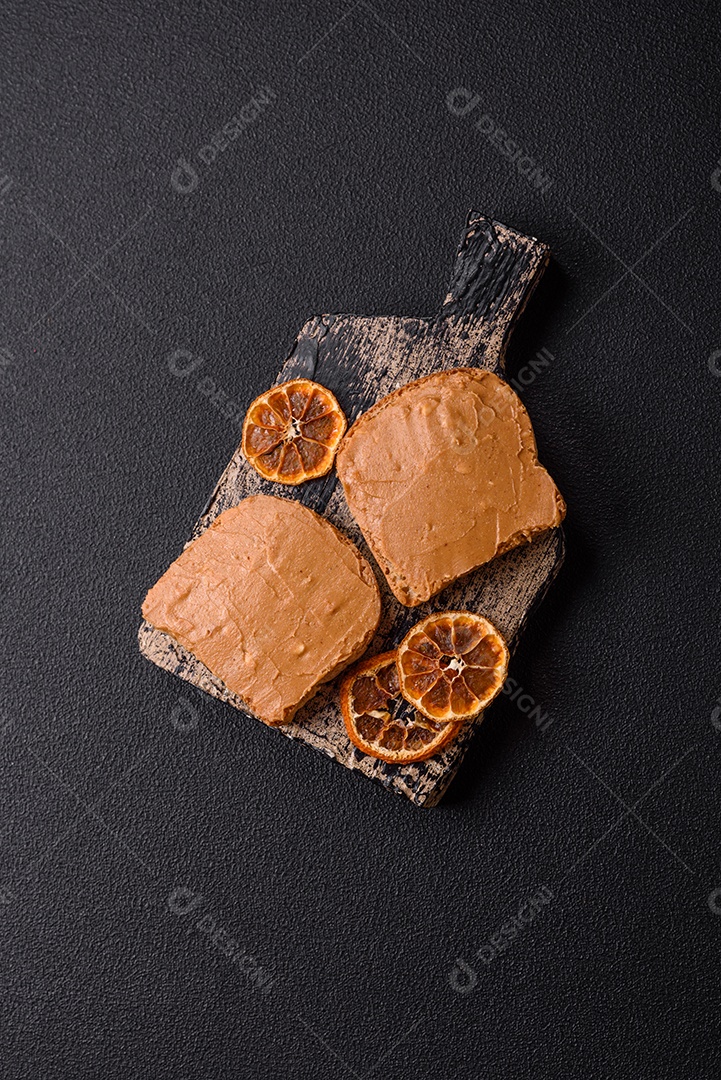 Delicioso sanduíche saudável com pão torrado e manteiga de amendoim em um fundo de concreto texturizado