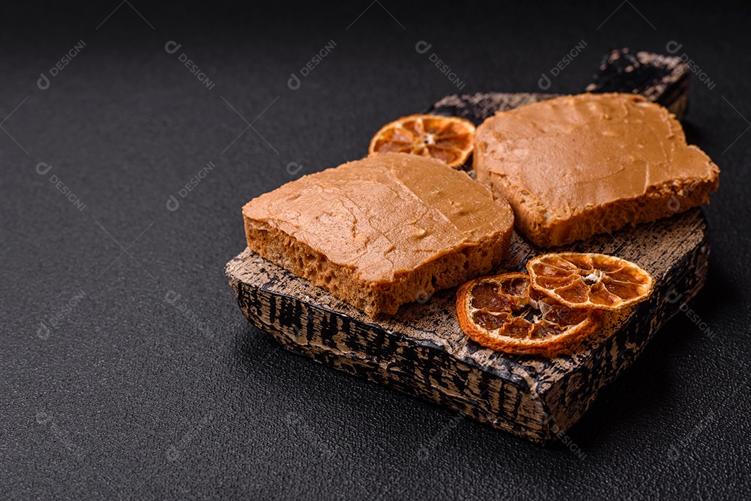 Delicioso sanduíche saudável com pão torrado e manteiga de amendoim em um fundo de concreto texturizado