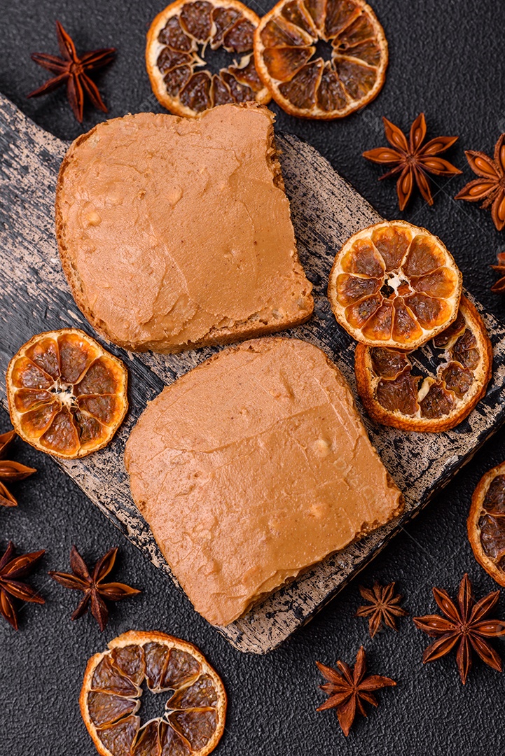 Delicioso sanduíche saudável com pão torrado e manteiga de amendoim em um fundo de concreto texturizado