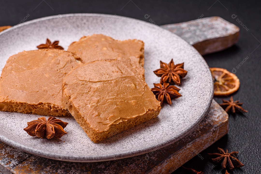 Delicioso sanduíche saudável com pão torrado e manteiga de amendoim em um fundo de concreto texturizado