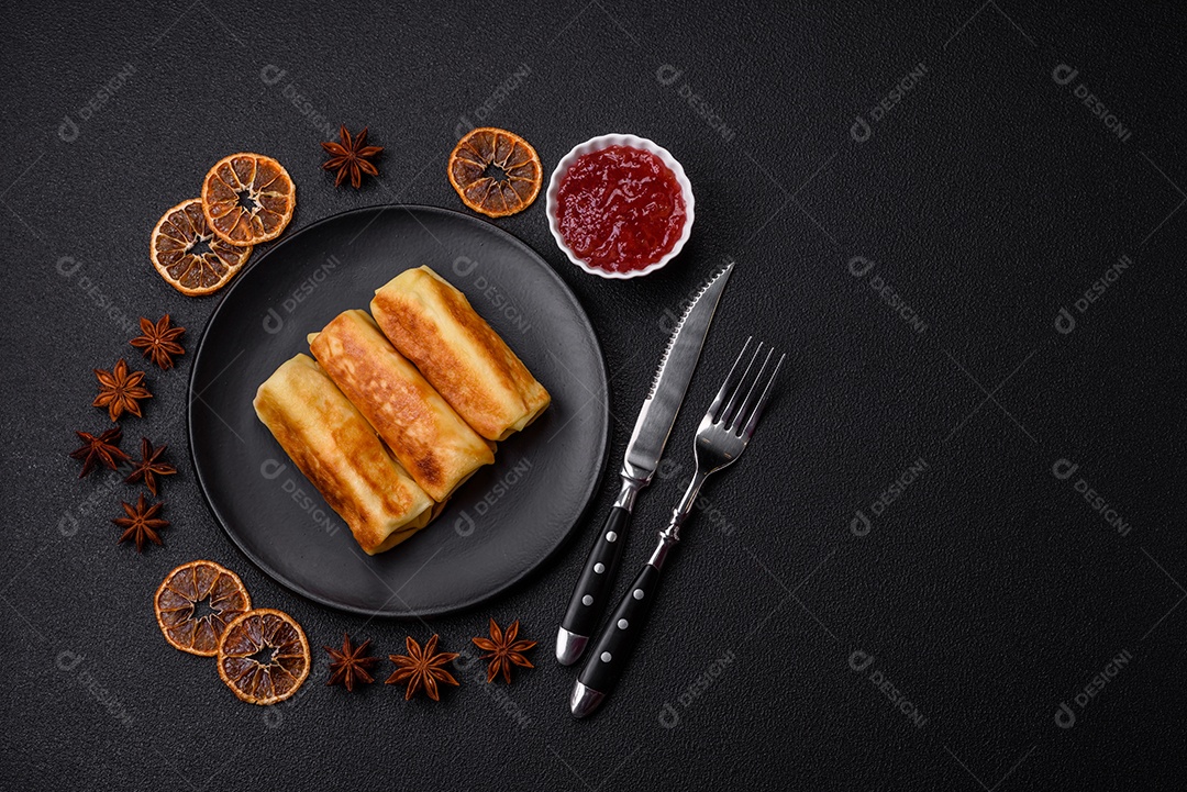 Deliciosas panquecas fritas com recheio roladas sobre um fundo escuro de concreto. Delicioso café da manhã nutritivo