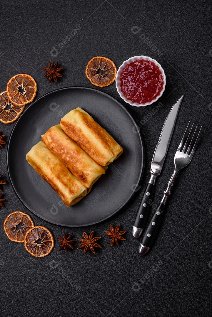 Deliciosas panquecas fritas com recheio roladas sobre um fundo escuro de concreto. Delicioso café da manhã nutritivo