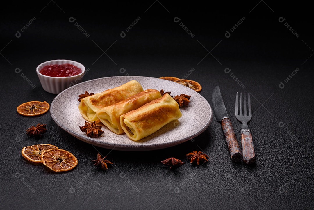 Deliciosas panquecas fritas com recheio roladas sobre um fundo escuro de concreto. Delicioso café da manhã nutritivo