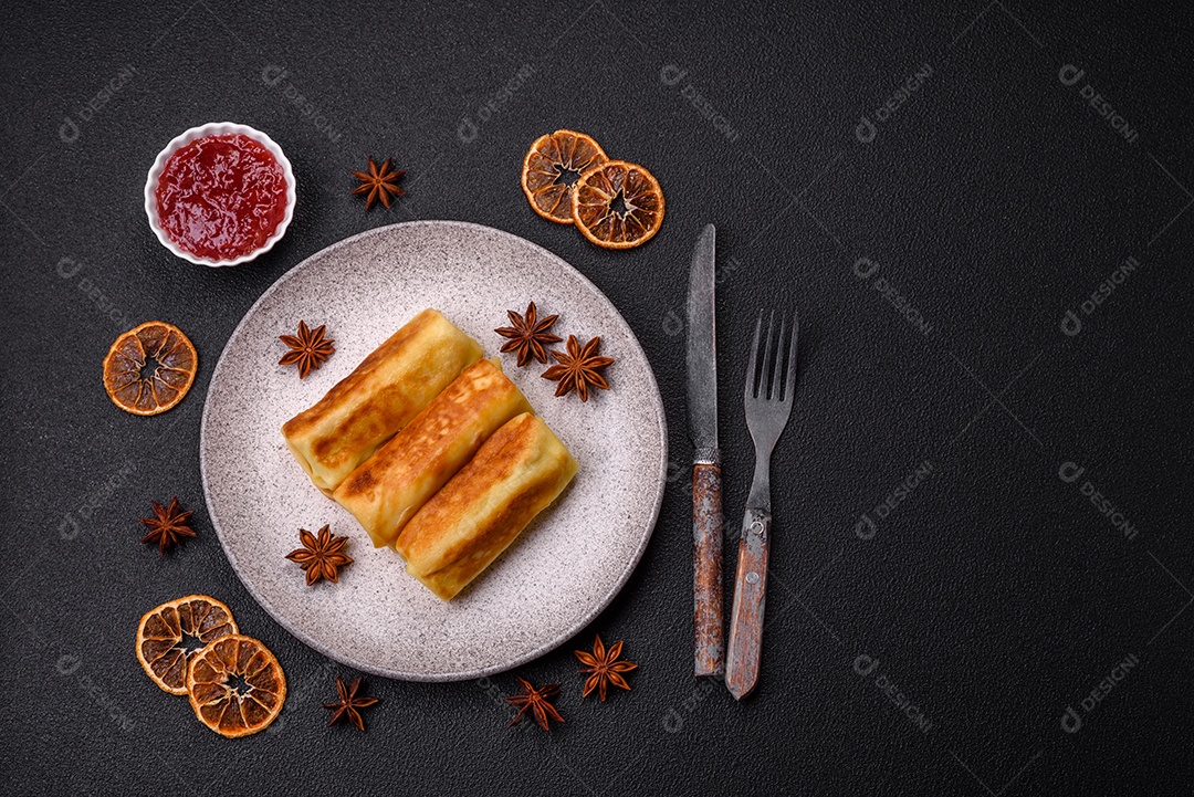 Deliciosas panquecas fritas com recheio roladas sobre um fundo escuro de concreto. Delicioso café da manhã nutritivo