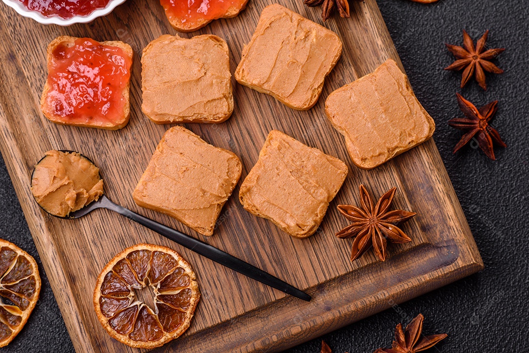 Delicioso sanduíche saudável com pão torrado e manteiga de amendoim em um fundo de concreto texturizado