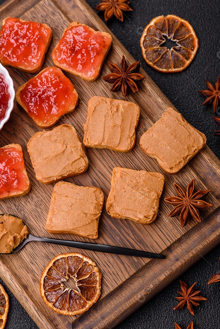 Delicioso sanduíche saudável com pão torrado e manteiga de amendoim em um fundo de concreto texturizado
