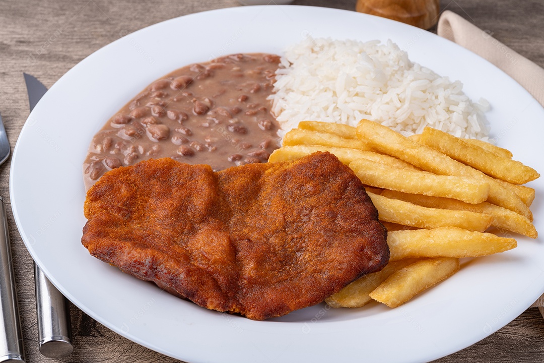 Comida arroz carne milanesa feijão e batatas fritas